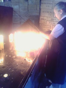 Freira acendendo uma de inúmeras velas num altar para Santo Antônio.