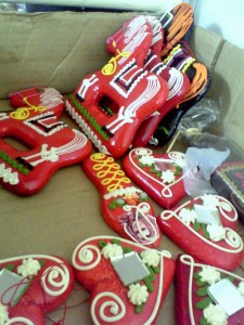 Biscoitos pintados com base vermelha e vários adornos feitos de açúcar, em forma de coração e cavalo.