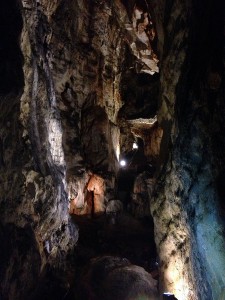 Um salão gigantesco de pelo menos 25 metros de altura. Longas estalactites no alto, várias estalagmites abaixo. Uma escada leva para o próximo nível da caverna. Luzes estrategicamente colocadas acentuam as formações rochosas. 